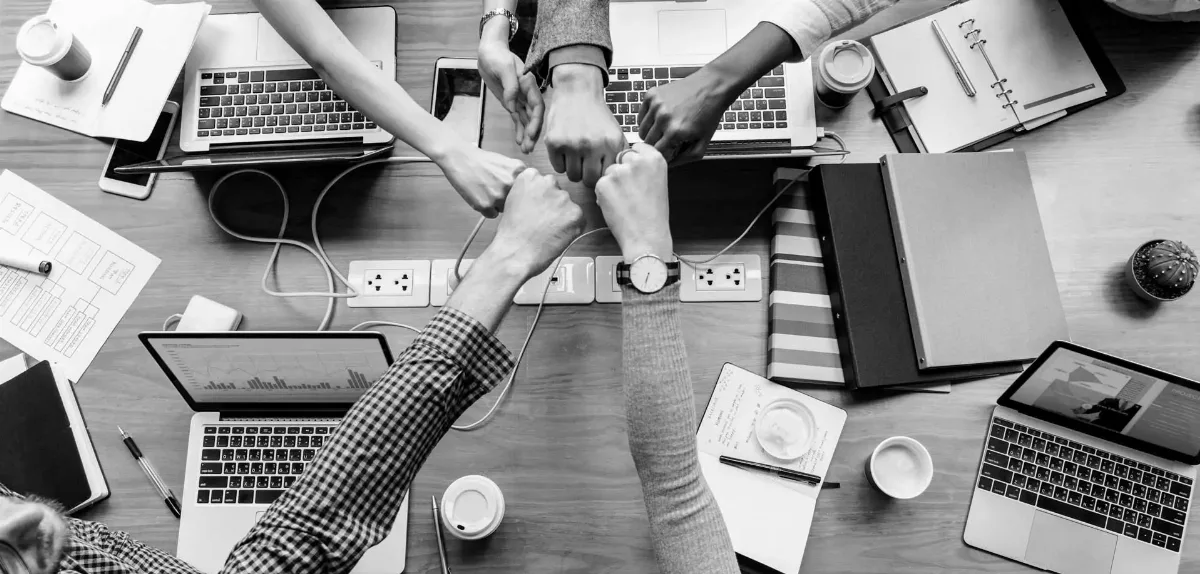 Equipo celebrando un acuerdo y logro empresarial.